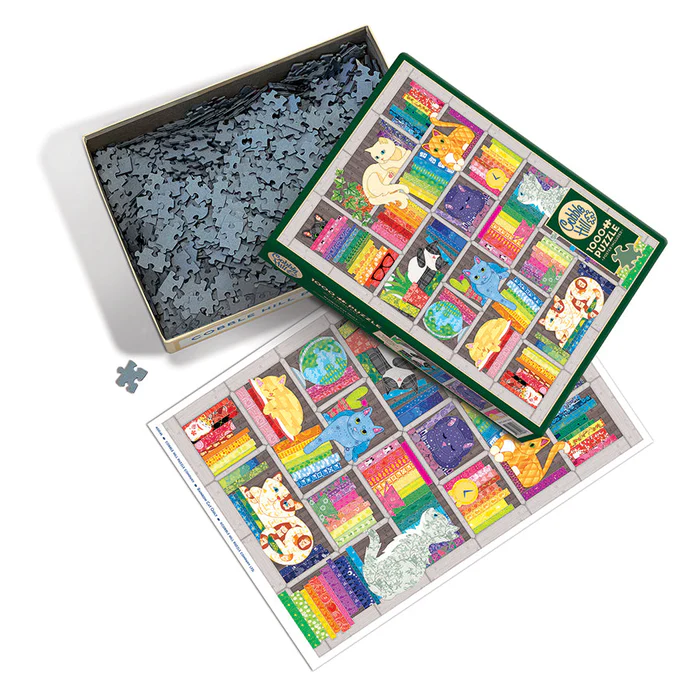 Cobble Hill 1000 Piece puzzle, poster included. Image of cats and quilting fabrics stacked on shelves in a rainbow. Pieces shown in box, with poster