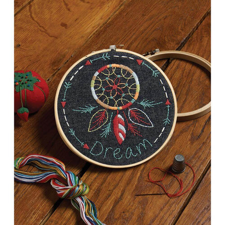 Finished product of dreamcatcher embroidery kit with dream catcher in the center of a circle of arrows, with the word Dream