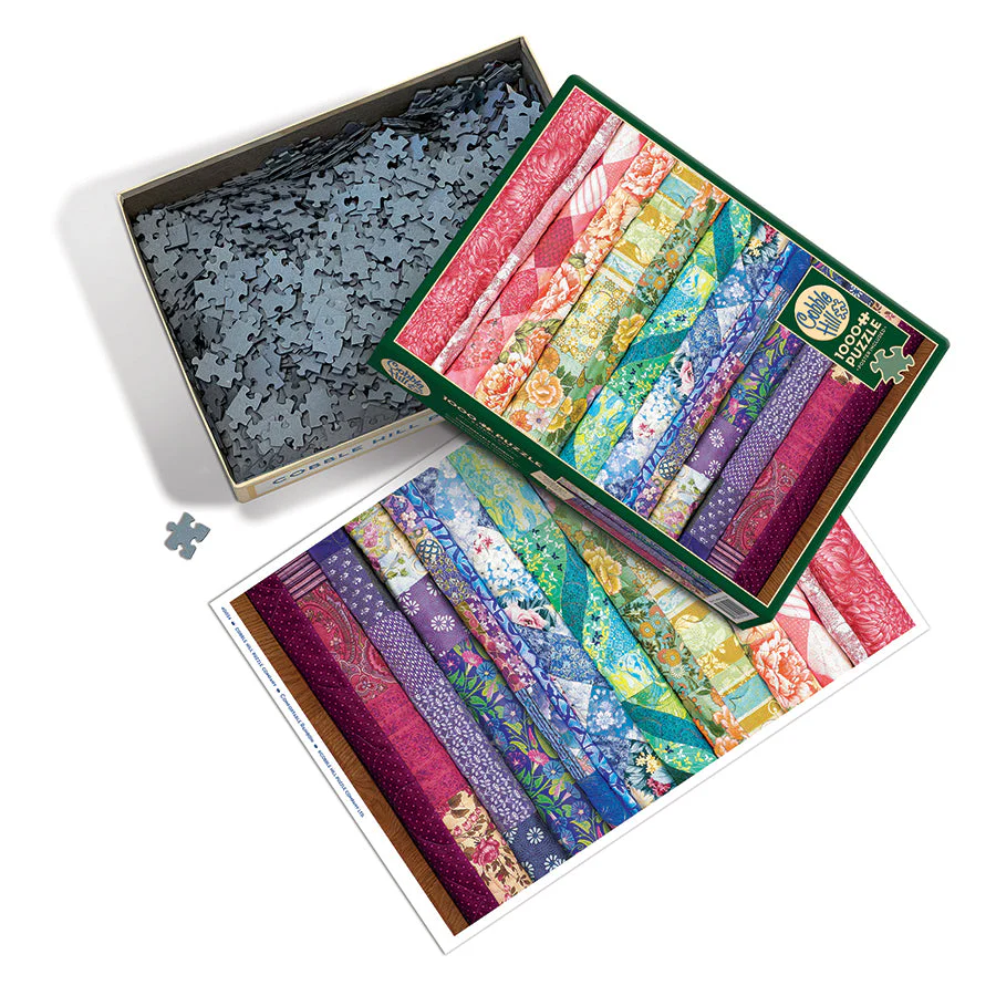 Cobble Hill 1000 Piece puzzle, poster included. Box shows image of quilts stacked and folded in a rainbow of colors with different fabric patterns. Pieces shown and poster included