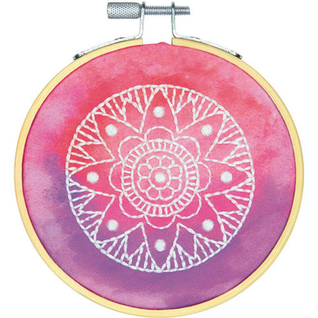 Finished product of Pink Mandala Embroidery kit with thread, hoop, fabric, needle and instructions. Pink and purple tye dye background with white thread mandala design