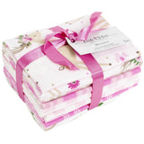 Fabric bundle of fat quarter pieces with the one on top showing a floral deer. Bundle is tied up in bright pink ribbon
